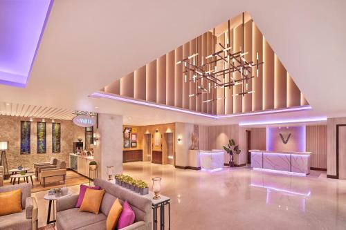 a lobby with couches and a staircase in a building at Vivanta Jammu City Centre in Jammu