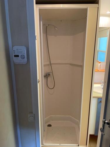 La salle de bains est pourvue d'une douche avec un tuyau. dans l'établissement Charmant Mobil-home climatisé avec 2 chambres et entièrement équipé, sauf draps en option, pour 5 personnes au maximum, à Sarlat-la-Canéda