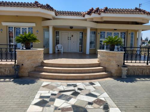 a home with stairs and a porch with a house at Vasilis House family room in Larnaka