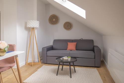 un salon avec un canapé et une table dans l'établissement Nouveau - L'indiana - Jardin partagé, barbecue, à Diemeringen
