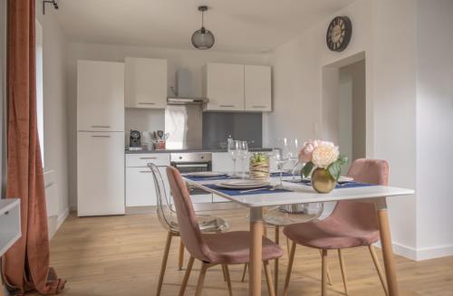 une cuisine blanche avec une table et des chaises dans l'établissement Nouveau - L'indiana - Jardin partagé, barbecue, à Diemeringen
