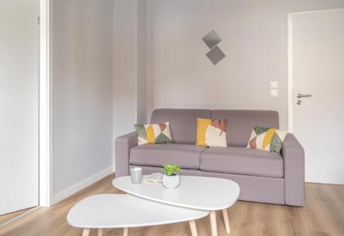 un salon avec un canapé et une table dans l'établissement Nouveau - L'Univers - Jardin partagé, barbecue, à Diemeringen