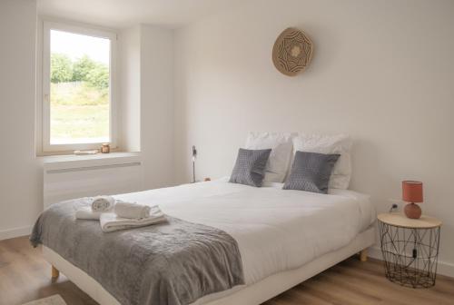 une chambre blanche avec un grand lit avec une fenêtre dans l'établissement Nouveau - L'Univers - Jardin partagé, barbecue, à Diemeringen