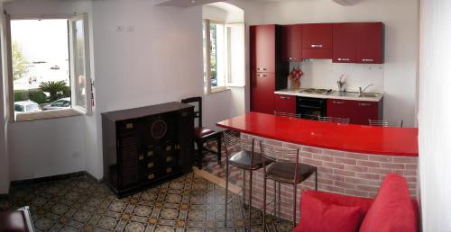 a kitchen with a red counter top in a room at Casa Flora in San Terenzo