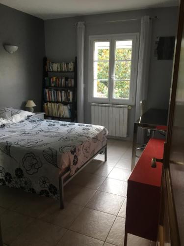 een slaapkamer met een bed en een boekenplank bij Villa avec piscine privée à Avignon in Avignon