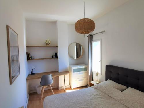 sypialnia z łóżkiem, biurkiem i lustrem w obiekcie Superbe appartement dans le Centre Historique w Montpellier