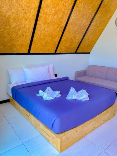 a bed with two pillows on top of it at พูลสวัสดิ์ รีสอร์ท อ่าวมะนาว in Changwat Prachuap Khiri Khan