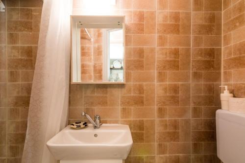 a bathroom with a sink and a mirror and a toilet at Pentofanoro Central Studio - Corfu Cozy Getaway in Corfu Town