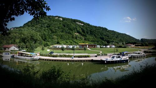 a group of boats docked next to a mountain at Maison La Tourelle in Baume-les-Dames