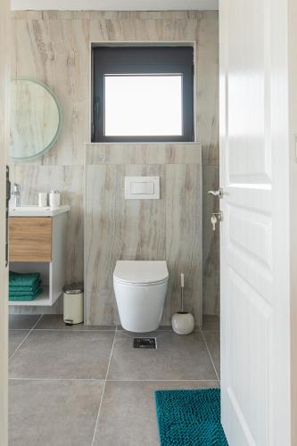 a bathroom with a toilet and a sink and a window at Solana's View - Ferienhäuser in ruhiger Lage, mit einer einzigartigen Aussicht, Infinity Pool, Free Parking und Wlan in Ulcinj