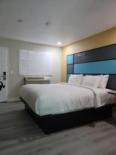 - une chambre avec un grand lit et des draps blancs dans l'établissement Quality Inn Victorville I-15, à Victorville