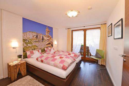 une chambre avec un lit et une grande fenêtre dans l'établissement Landhaus Wild, à Riezlern