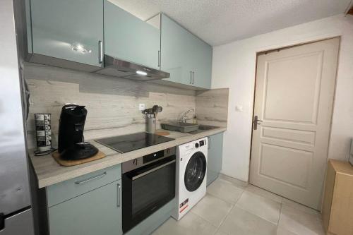 uma cozinha com um lavatório e uma máquina de lavar roupa em Small villa 40m with terrace near the beach em Fleury