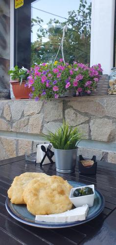 a plate of food on a table with flowers at Guest House Compass in Lozenets