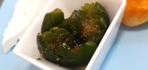 a bowl of green peppers with sauce on it at Guest House Compass in Lozenets