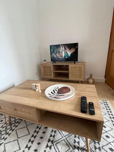 un salon avec une table basse et une télévision dans l'établissement La pause détente, à Saint-Hilaire-du-Harcouët