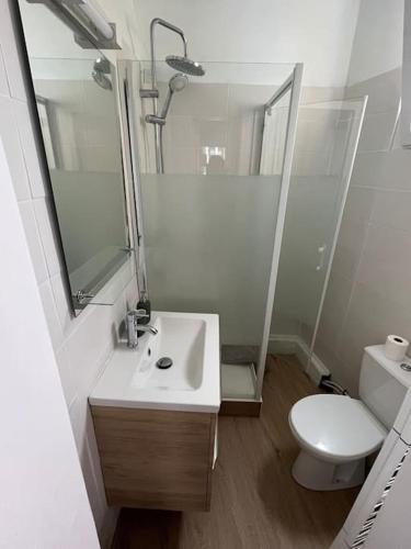 une salle de bain avec un lavabo, des toilettes et un miroir dans l'établissement La pause détente, à Saint-Hilaire-du-Harcouët
