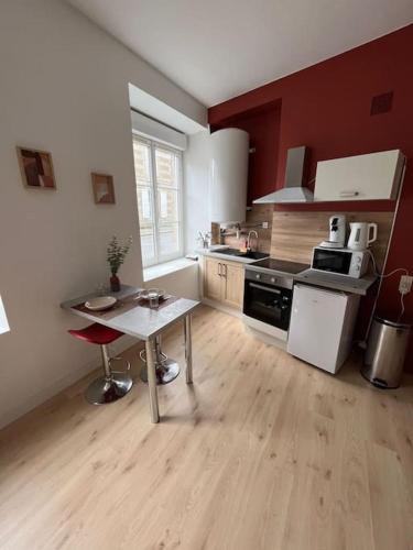 une petite cuisine avec une table dans une pièce dans l'établissement La pause détente, à Saint-Hilaire-du-Harcouët