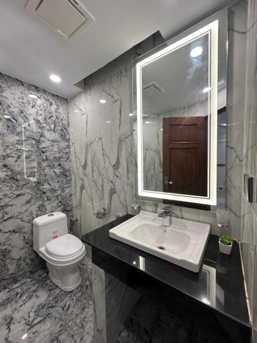 ein Badezimmer mit einem WC, einem Waschbecken und einem Spiegel in der Unterkunft Emeralds Villa Islamabad in Islamabad