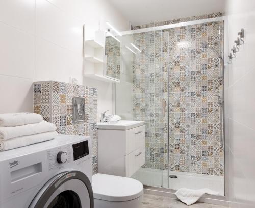 ein Bad mit einer Dusche und einer Waschmaschine in der Unterkunft ApartamentyGdanskEU - Mieszkanie Mewa in Sopot