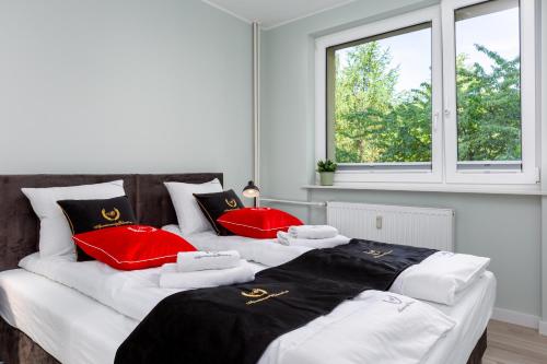 two beds in a room with red and white pillows at ApartamentyGdanskEU - Mieszkanie Mewa in Sopot