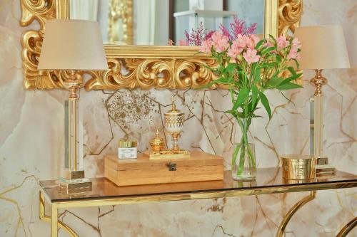 a table with a vase of flowers and a mirror at Hotel Wiosna in Rabka