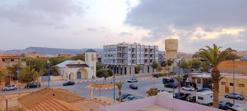 una ciudad con una calle con coches y edificios en SULTANA Beach Riad en Saidia 