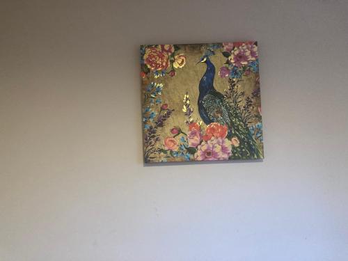 een schilderij van een pauw aan een muur bij C&C in Croydon