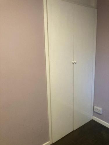een kamer met een witte deur en een muur bij C&C in Croydon