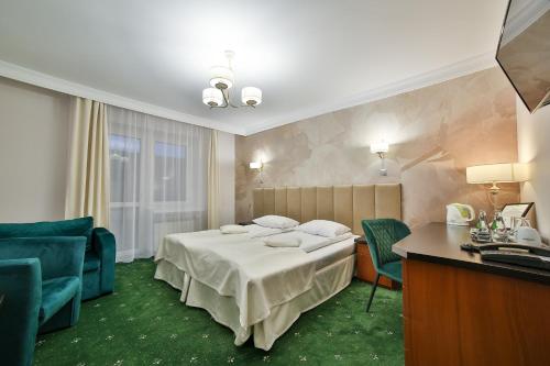 a hotel room with a bed and a table and chairs at Hotel Wiosna in Rabka