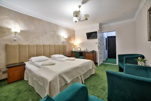 a hotel room with a bed and chairs at Hotel Wiosna in Rabka