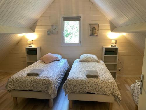 1 Schlafzimmer mit 2 Betten und einem Fenster in der Unterkunft Les Chalets de SAUMUR, Piscine & Parc boisé, 100m du CadreNoir in Saumur