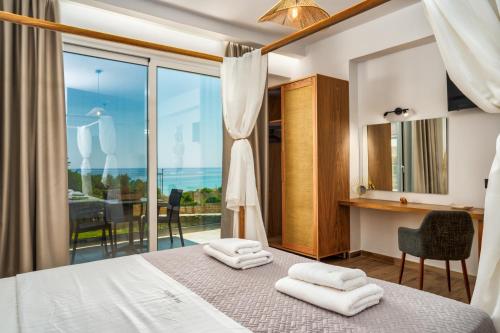 a bedroom with a bed and a view of the ocean at Amoudi Studios Apartments Hotel in Amoudi