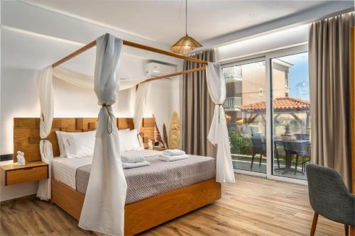 a bedroom with a canopy bed and a balcony at Amoudi Studios Apartments Hotel in Amoudi