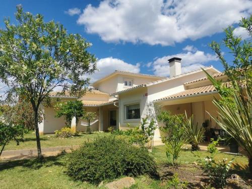 a large white house with trees in the yard at Cantinho da Alice Family Villa in Sertã