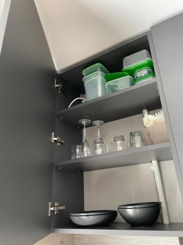 una cocina con dos cuencos negros en estanterías en TK apartamenti, en Rēzekne