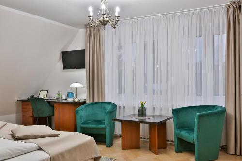 a bedroom with a table and chairs and a bed at Hotel Wiosna in Rabka