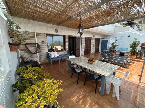 um pátio com uma mesa e cadeiras num pátio em Apartment with a great terrace, sea and land views em Mojácar