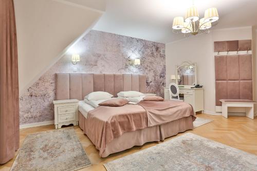 a bedroom with a large bed and a staircase at Hotel Wiosna in Rabka