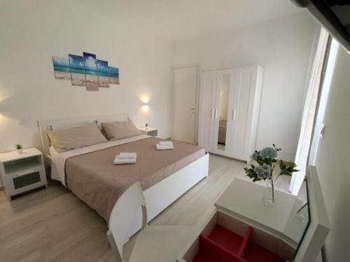a white bedroom with a bed and a table at Sabbia di Mare in Termoli