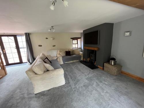 a living room with a couch and a television at The Cottage in Carlisle