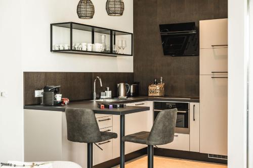 una cocina con encimera y 2 sillas. en Privilegium Lazise, en Lazise