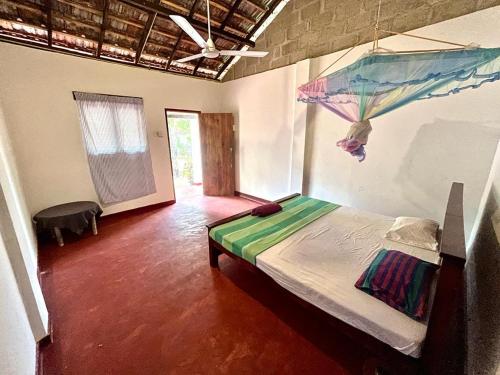 a bedroom with a bed with an umbrella hanging from the ceiling at Lake House Homestay in Anuradhapura