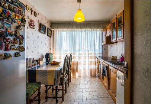 a kitchen with a table and chairs and a window at Chambre chez Victor in Lingolsheim