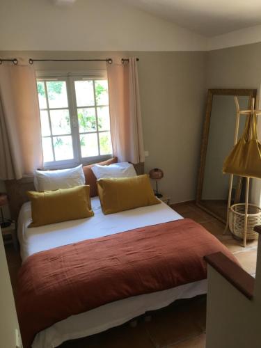 a bedroom with a large bed with a large window at Le Jas du Romarin in Callas