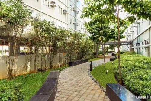 a park with benches and trees in front of a building at 2BR SMDC Trees w/Netflix&WIFI near the POOL. T65F in Manila