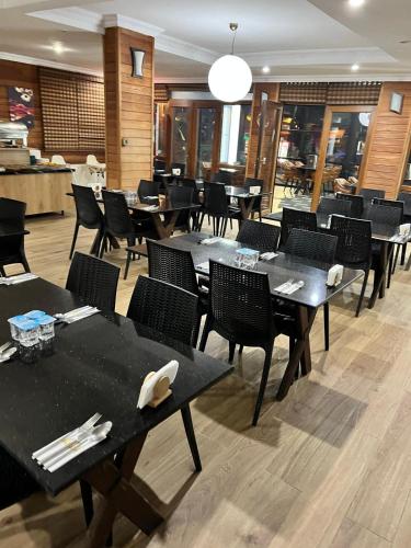 a dining room with black tables and chairs at Hayde otel in Çamlıhemşin