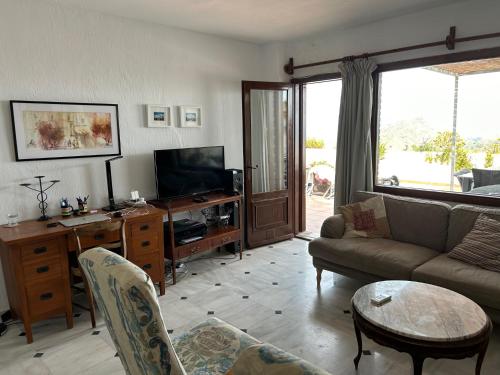 uma sala de estar com um sofá e uma televisão em Apartment with a great terrace, sea and land views em Mojácar