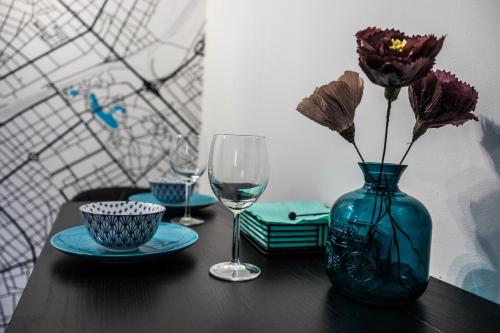 une table avec un vase avec des fleurs et un verre dans l'établissement Porta Danube, à Budapest