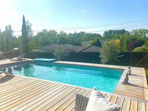 - une piscine dans une cour avec une terrasse en bois dans l'établissement Villa Bois Piscine Bordeaux, à Bonnetan